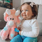 Toddler smiling with pink dinosaur plushy soft toy unique baby gift